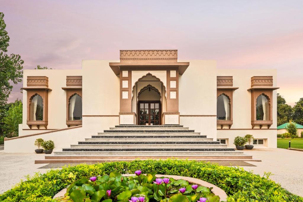 a building with stairs and flowers in front of it at ZANA Luxury Forest Resort, Ranthambore in Sawāi Mādhopur