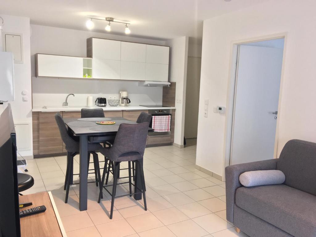 une cuisine et un salon avec une table et des chaises dans l'établissement Appartement centre plage à pieds, à Arcachon