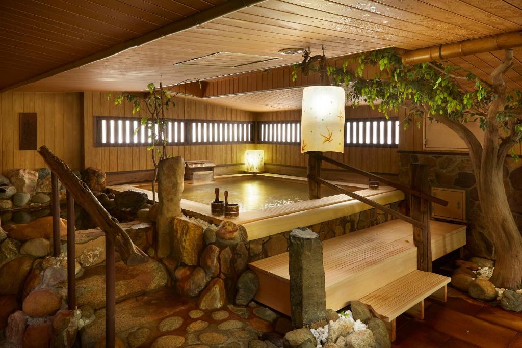 uma banheira num quarto com uma árvore em the b suidobashi em Tóquio