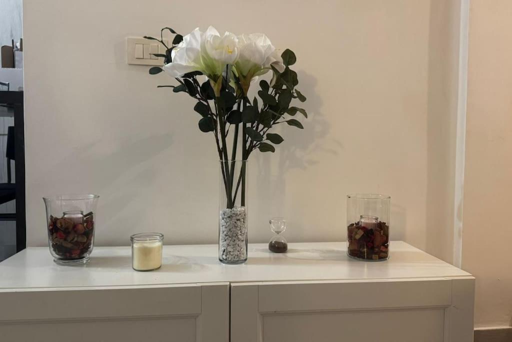 a table with a vase with white flowers and candles at Casa Lido in Lido di Ostia
