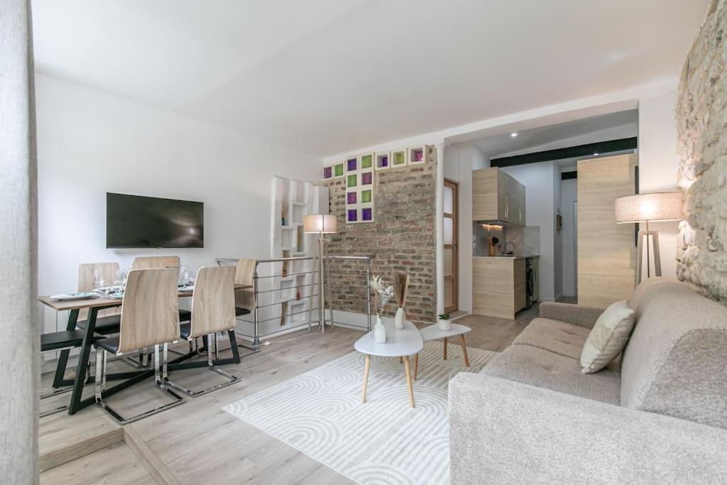 un salon avec un canapé et une salle à manger dans l'établissement Cosy appartement Paris 20e, à Paris