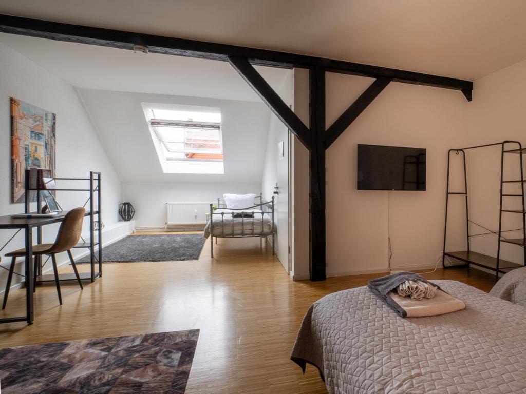 a bedroom with a bed and a tv on a wall at Urban Living unter den Dächern der Göttinger Altstadt in Göttingen