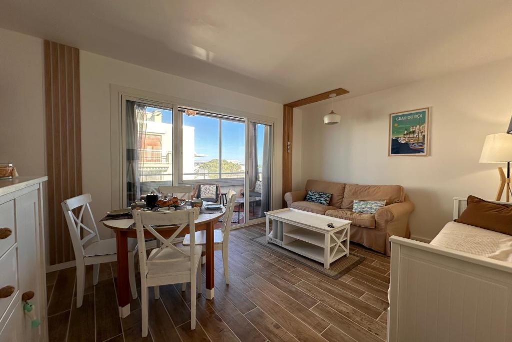 un salon avec une table et un canapé dans l'établissement Côté Mer - Appartement vue mer en première ligne, au Grau-du-Roi