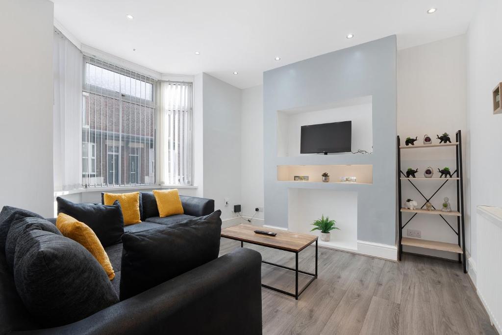 Thornaby on TeesにあるClassic 4-Bedroom Retreat close to Infinity Bridgeのソファとテーブルのあるリビングルーム
