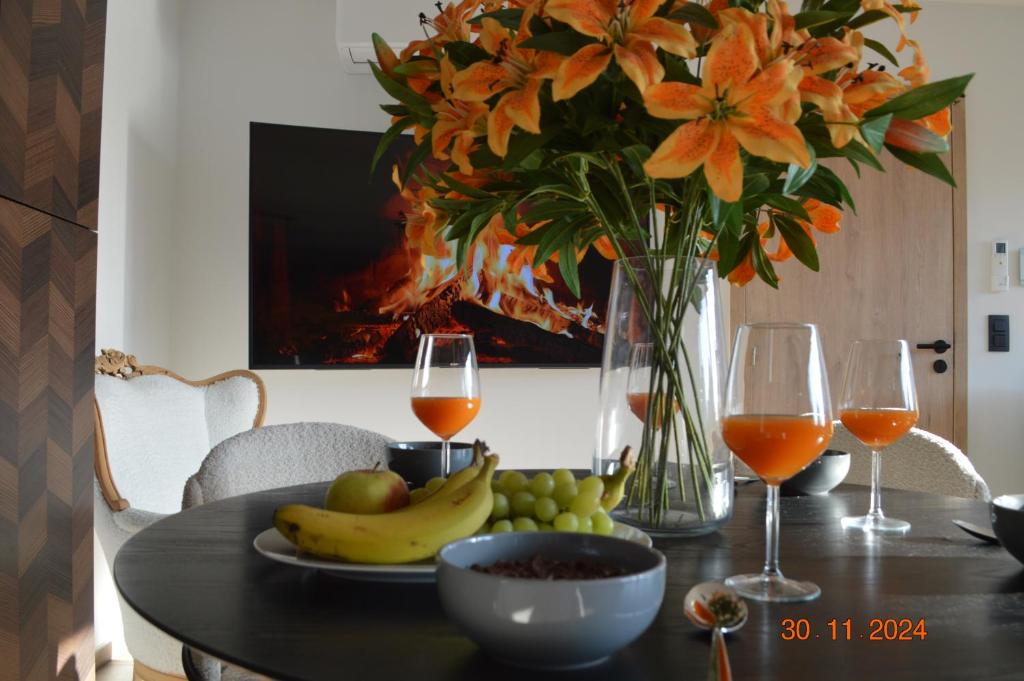 汉西斯Bella villa - 4 personnes的一张桌子,上面放着一盘水果和两杯葡萄酒