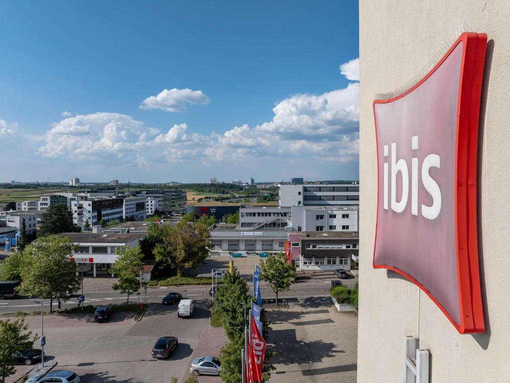 a bus sign on the side of a building with a parking lot at ibis Stuttgart Airport Messe in Leinfelden-Echterdingen