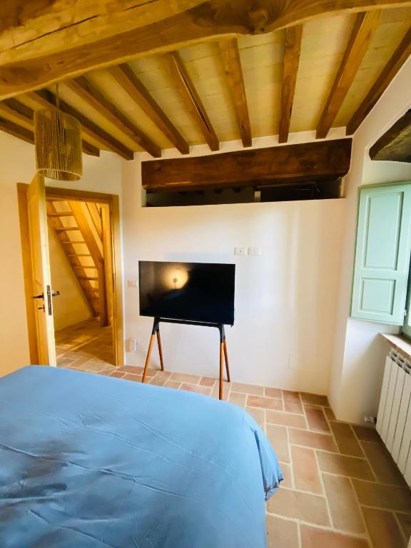 une chambre avec un lit et une télévision à écran plat dans l'établissement Villa Angela - Ranza 55, à Lugnano