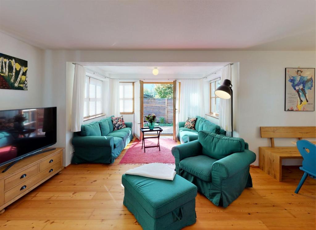 a living room with blue couches and a tv at Ferienhaus im modernen Landhauscharme mit Bergblick und Garten in Bischofswiesen