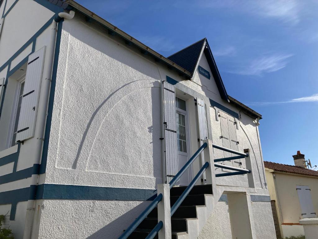 - un bâtiment bleu et blanc avec des escaliers dans l'établissement Villa l'Aurore - Maison de vacances tout confort face à la plage des 5 Pineaux, à Saint-Hilaire-de-Riez