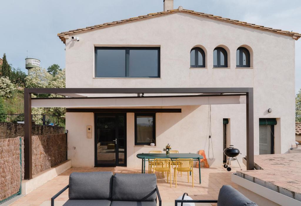 a home with a patio with a table and chairs at La Figuera in Ultramort