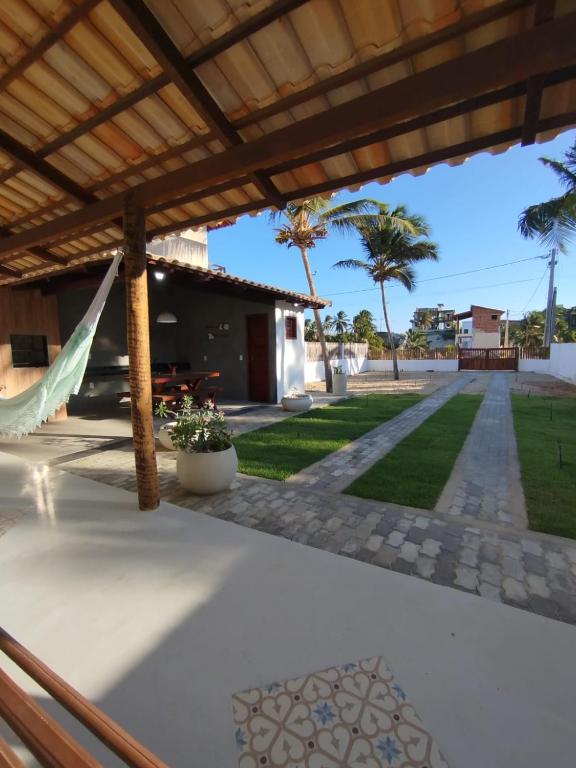a patio with a hammock and a yard at Xalé da Xica in Amontada
