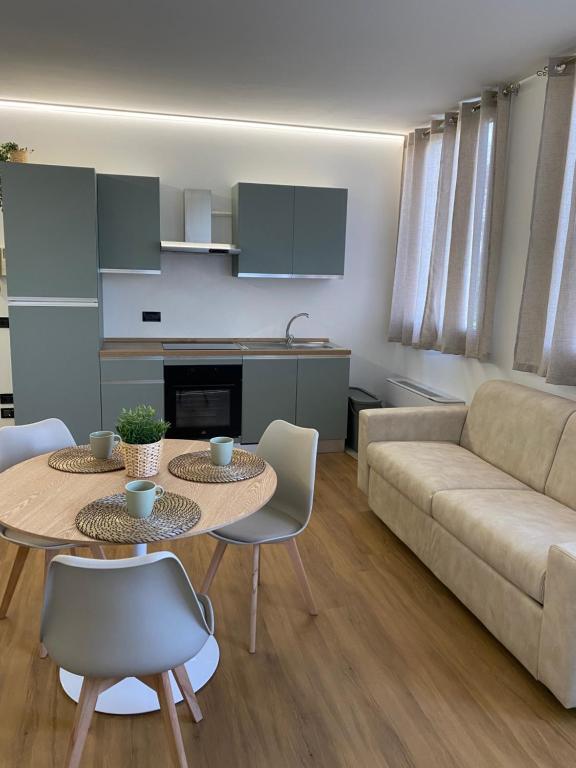 a living room with a couch and a table and chairs at La casetta al parco in Ponte San Nicolo
