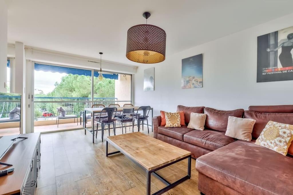 un salon avec un canapé et une table dans l'établissement Lovely 2BR Flat with terrace and parking near the beach, à Cannes