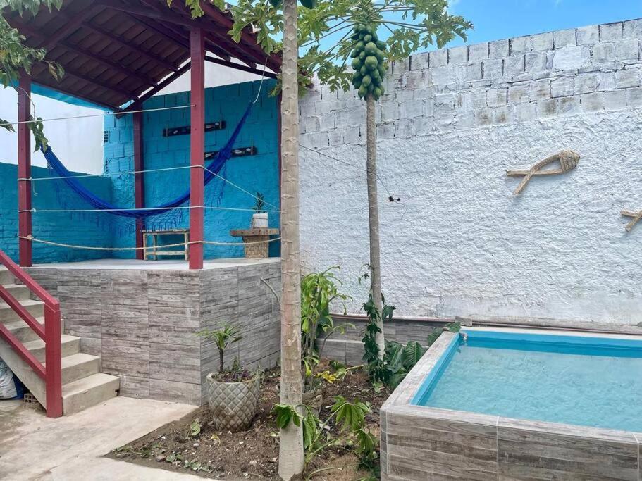 a house with a swimming pool next to a wall at Aconchego em Gravatá in Gravatá