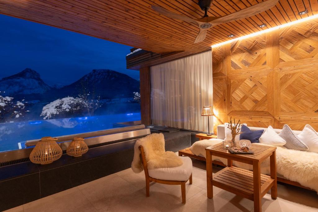 a bedroom with a large window with a bed and a table at Hotel Seevilla Wolfgangsee in St. Wolfgang