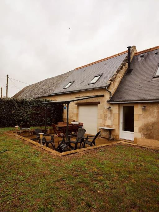 une maison avec une table et des chaises dans une cour dans l'établissement Gite charme en pierre à la campagne, à Chouzé-sur-Loire