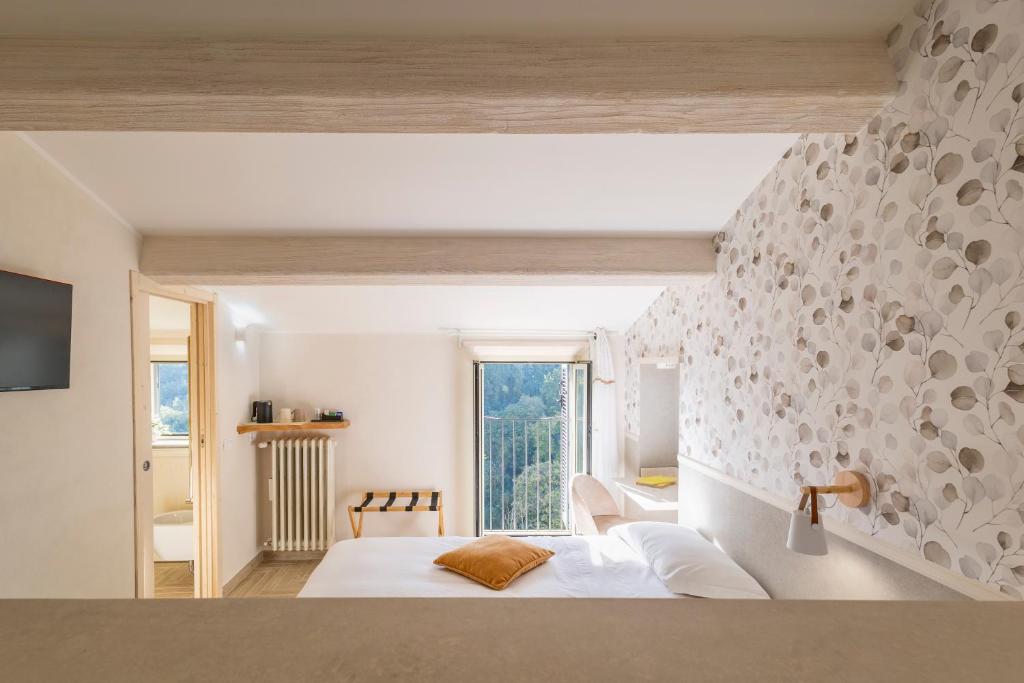 sypialnia z białym łóżkiem i dużym oknem w obiekcie B&B La Rocca w mieście Caprarola