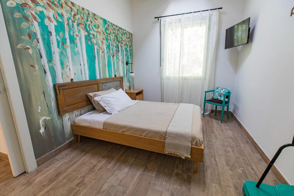 a bedroom with a bed and a painting on the wall at Saranto, Maison du charme - Nel cuore verde dell'Emilia in Carpi