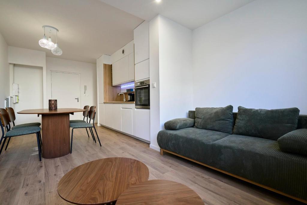 un salon avec un canapé et une table dans l'établissement T2 chic et contemporain au RDC - proche de Lille, à Mons-en-Baroeul