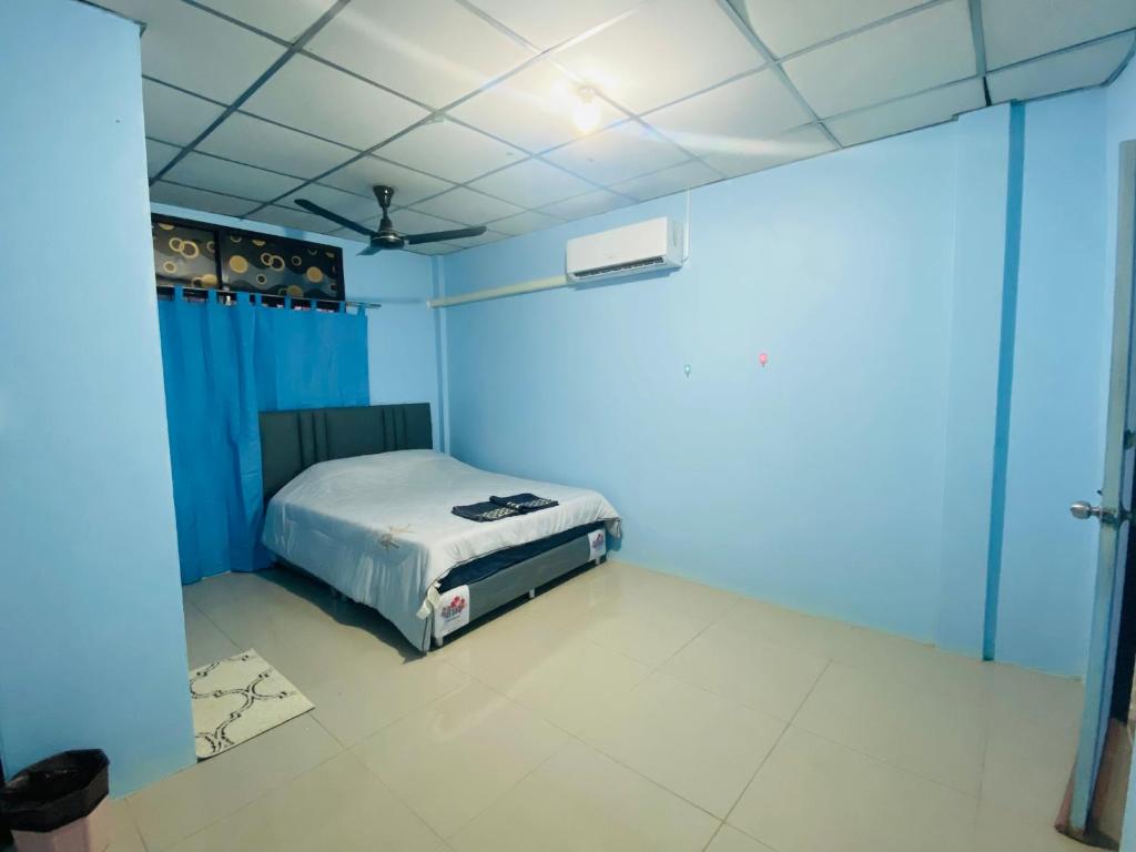 Un dormitorio con una cama en una habitación azul. en Walking Street Pattaya Beach Ordinary Rooms Guest House วอล์คกิ้งสตรีทพัทยาชายหาดพัทยาห้องธรรมดาเกสท์เฮ้าส์, en Pattaya central