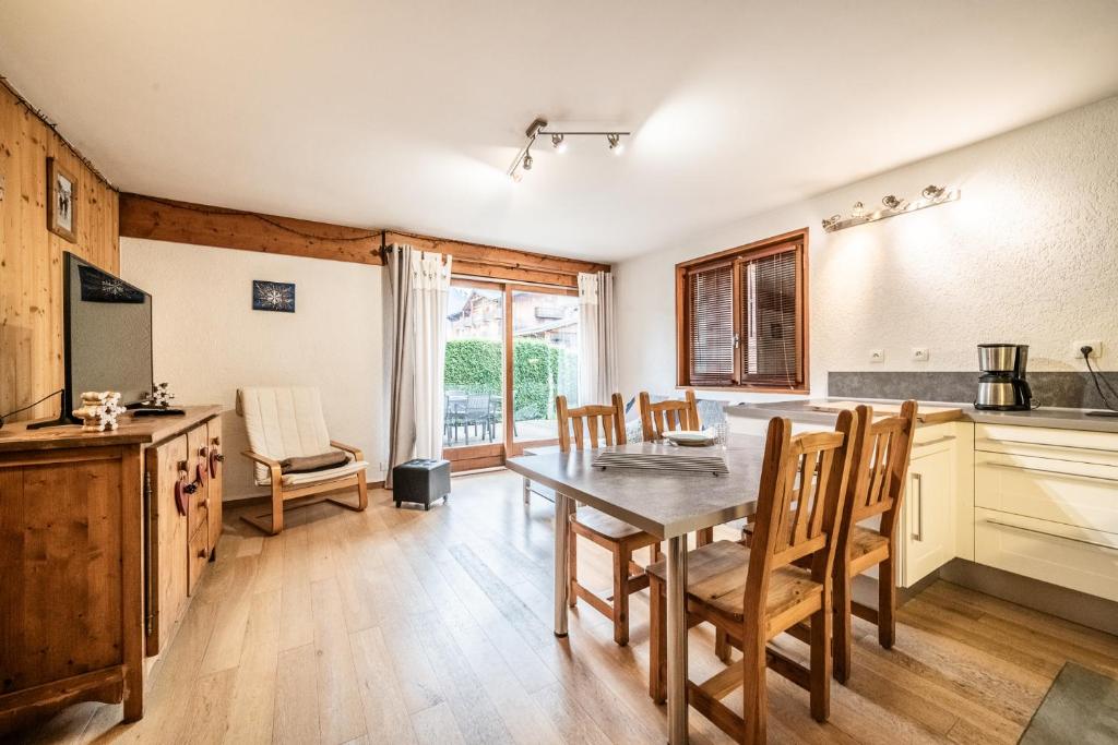 une cuisine et une salle à manger avec une table et des chaises dans l'établissement Fleur de sel - Agréable 2 chambres avec terrasse, à Morzine