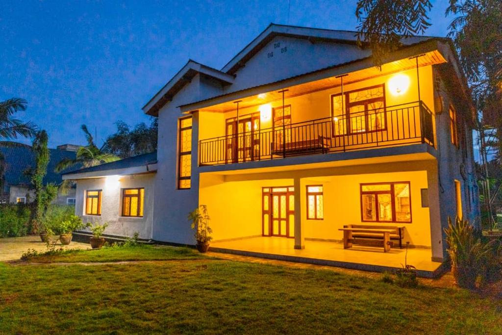 a large yellow house with a bench in front of it at Mara Home 1 in Arusha