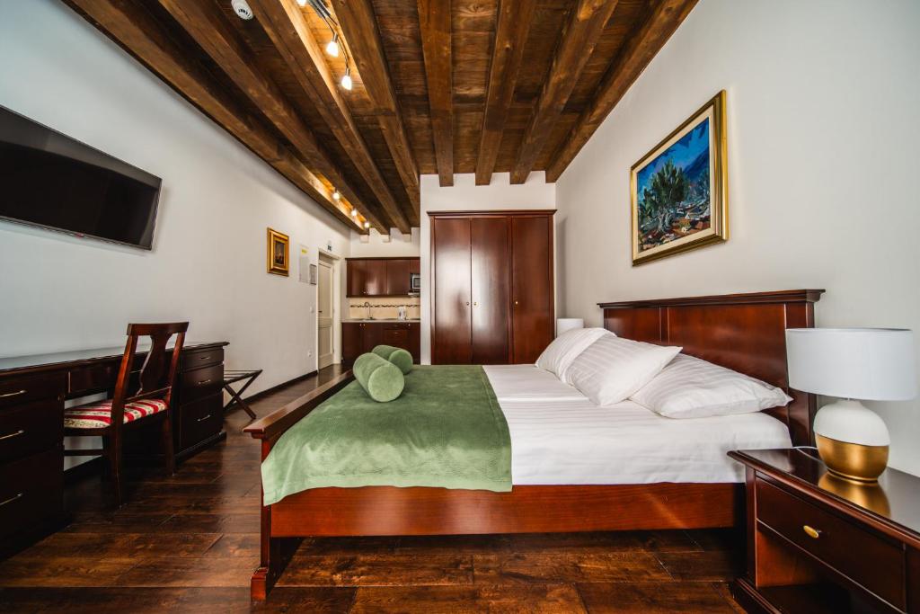 a bedroom with a bed and a desk and a television at SUNce Palace Apartments with free offsite parking in Dubrovnik