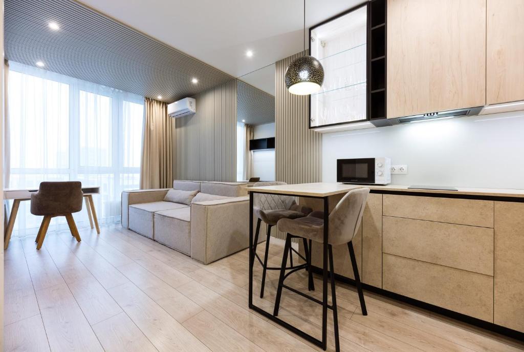a kitchen and living room with a table and a couch at Nyvky Like Home - Файна Таун із сезонним басейном - Кв 58 in Kyiv