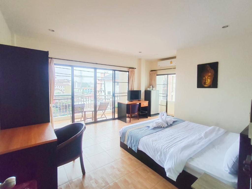 a bedroom with a bed and a desk and a window at L&K2023 Residence in Patong Beach
