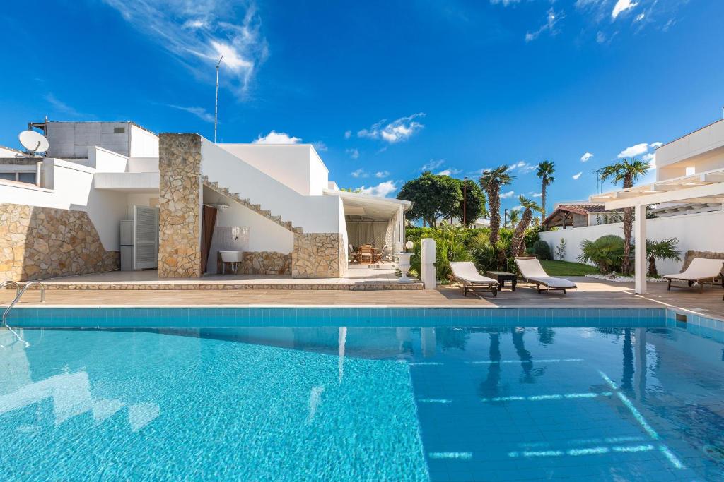 une piscine devant une villa dans l'établissement Villa Goccia by BarbarHouse, à Torre dell'Orso