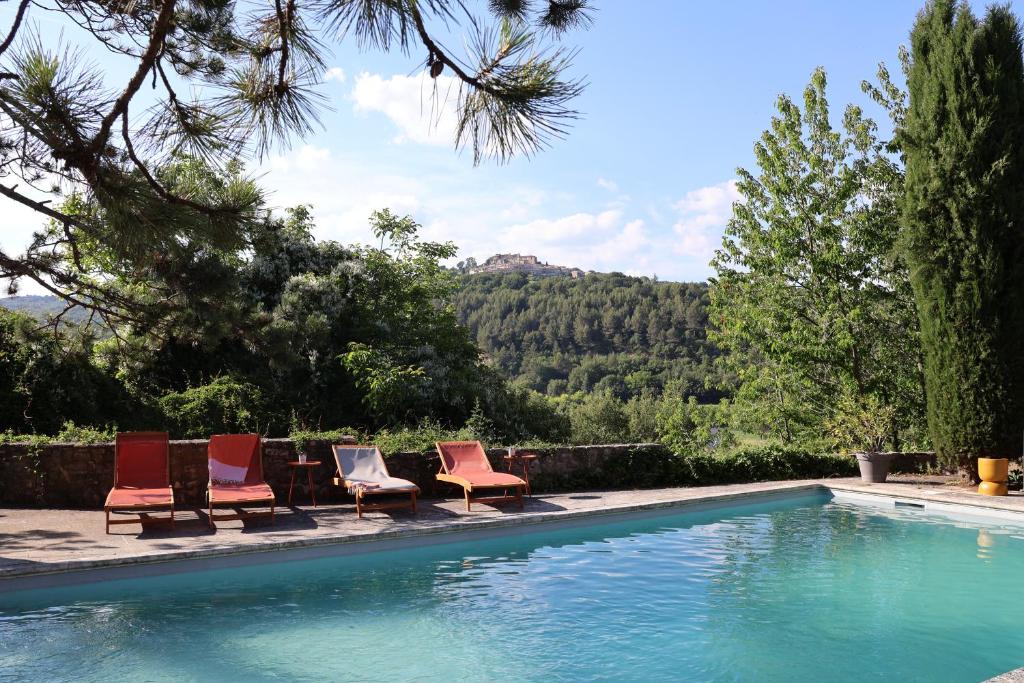 un groupe de chaises assises à côté d'une piscine dans l'établissement Auberge du Boisset, à Saint-Martin-de-Castillon