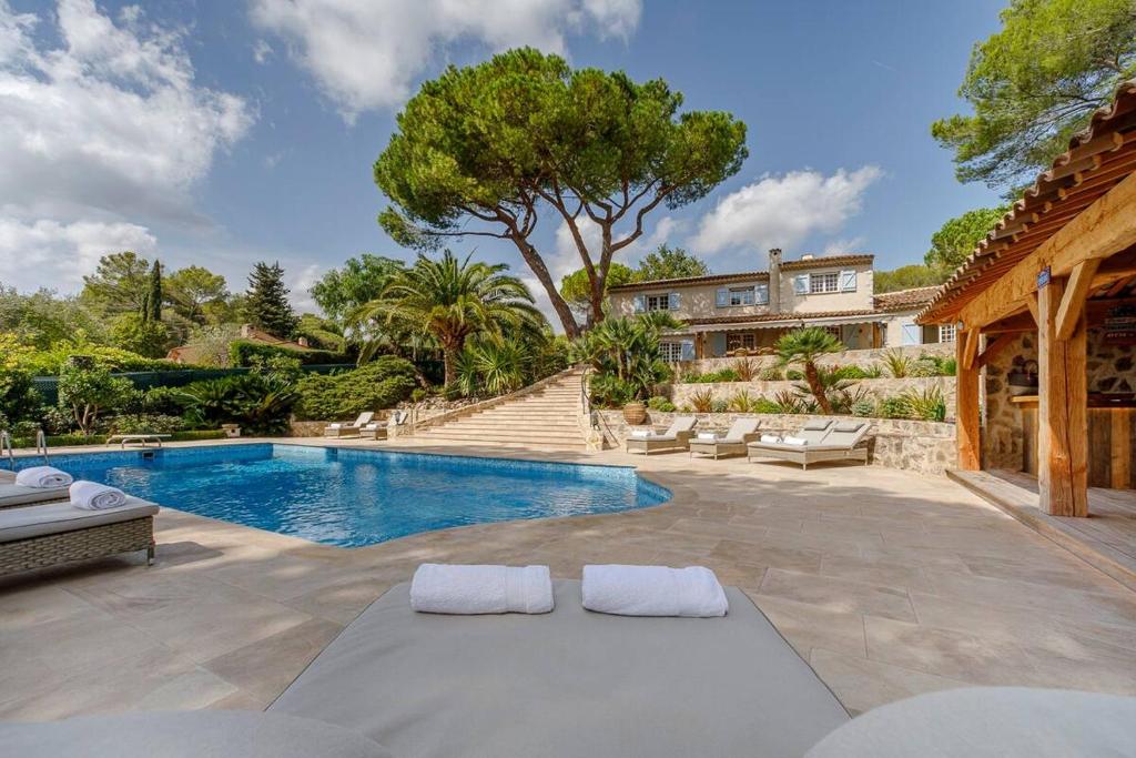 une piscine dans une cour avec une maison dans l'établissement Villa Les Palmier's, à Mouans-Sartoux