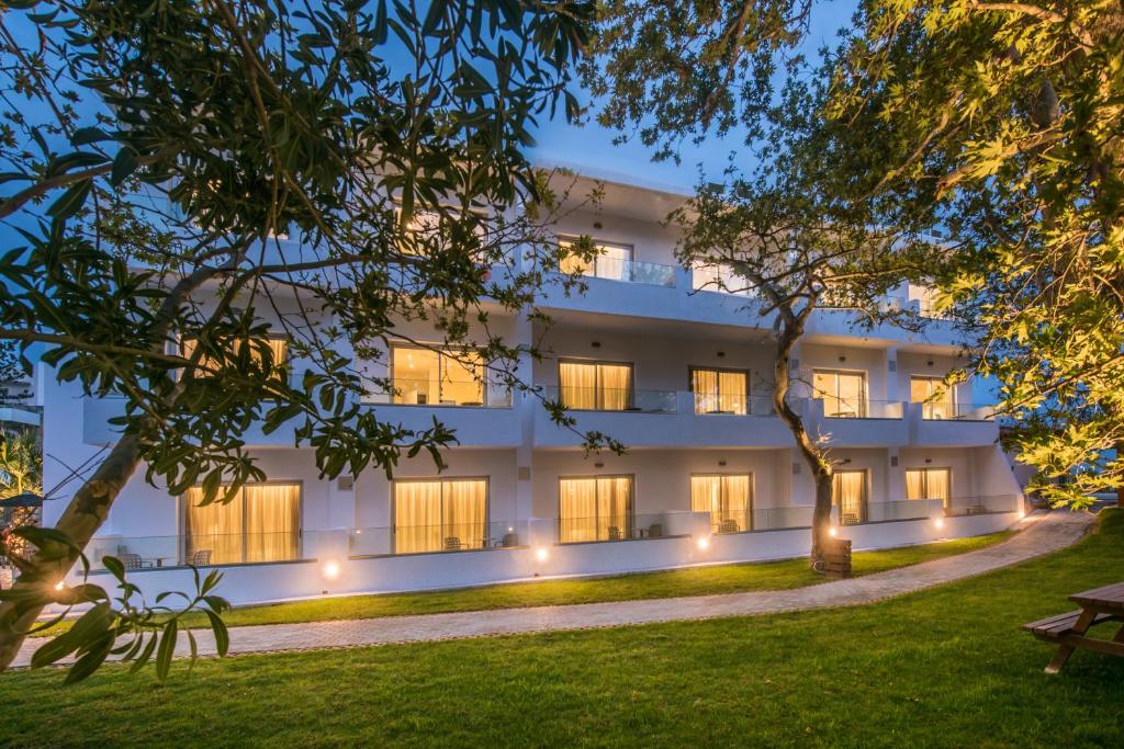 an exterior view of a building at night at South Coast Hotel in Makry Gialos