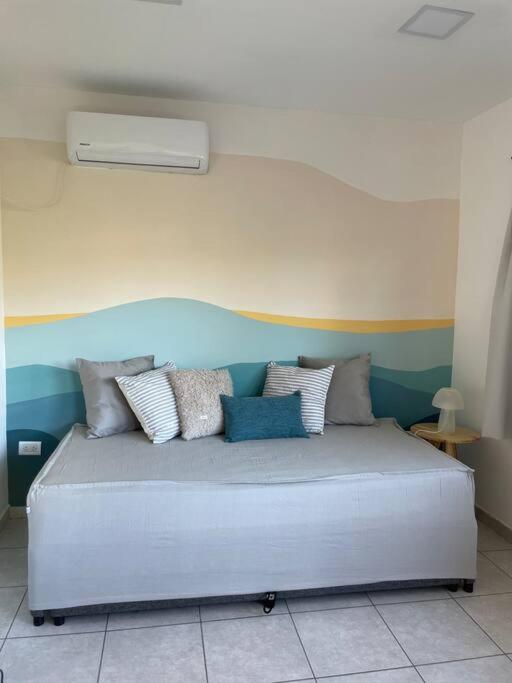 a bed with pillows on it in a room at EKÜ Chapa Tiny House - Playa Luna Roja in La Estafeta