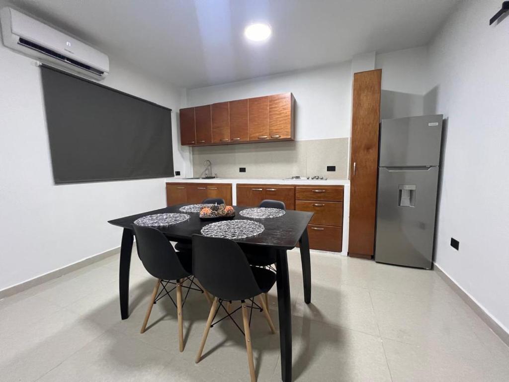 Una cocina con una mesa negra y sillas negras. en Apartamento en Porlamar, en Porlamar