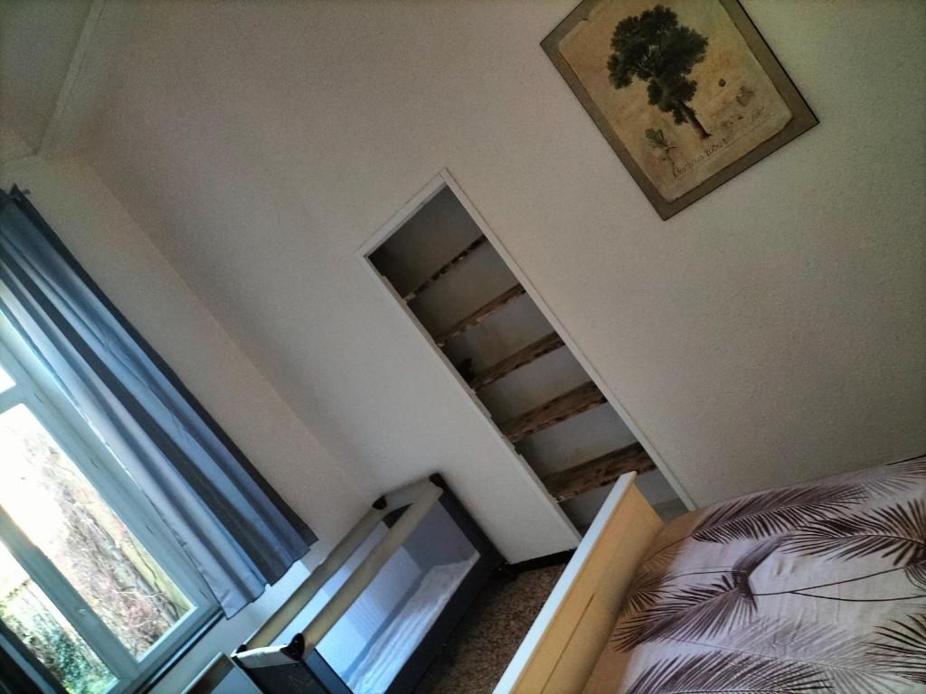 a bedroom with a staircase and a bed and a mirror at Le petit paradis in Saint-Pons-de-Thomières