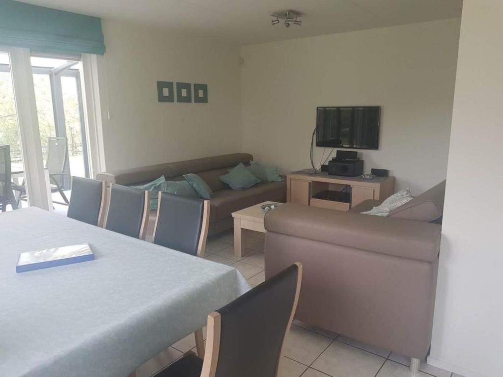 una sala de estar con un sofá y una mesa en Coastal Bungalow w Garden, en Breskens