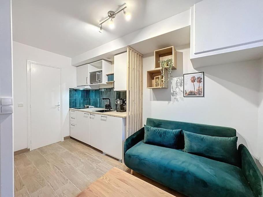 un salon avec un canapé bleu et une cuisine dans l'établissement My home perrache, à Lyon