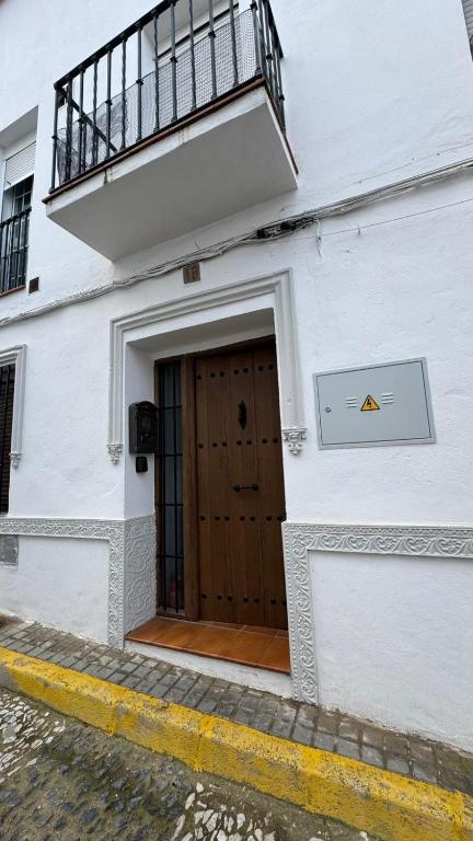 Edificio blanco con puerta de madera y balcón en Acogedora casa en Aroche, en Aroche