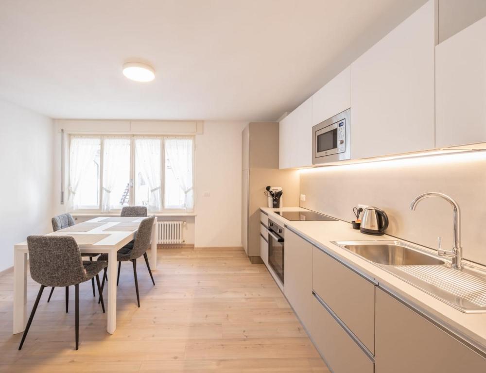 a kitchen with a table and a dining room at Appartamento Dolomiti Dream 2 in Falcade