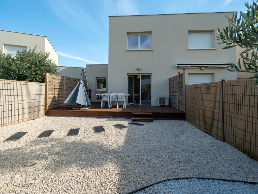 une maison blanche avec une clôture et une terrasse dans l'établissement La Dune 41 - VILLA 4P7, à Valras-Plage