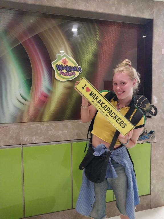 a young girl dressed as a mermaid holding a sign at WakakaPackers in Kuala Lumpur