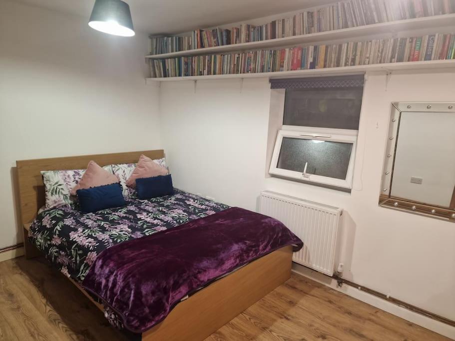a bedroom with a bed and a window at Comfortable stay in Wembley in London