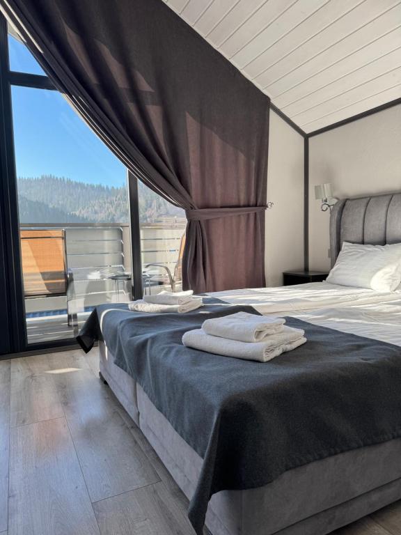 a bedroom with two beds and a large window at Prostir 65 in Slavske