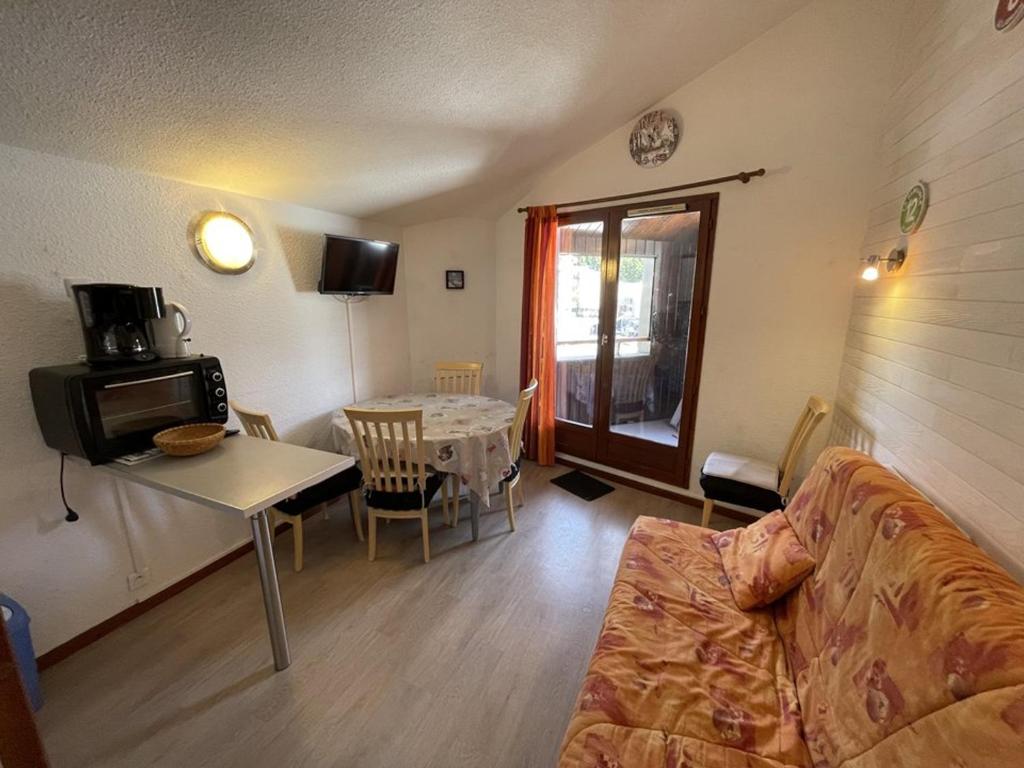 un salon avec un canapé et une table dans l'établissement Charmant T2 cabine au Lioran, balcon sud-est, 4 personnes - FR-1-787-98, à Laveissière