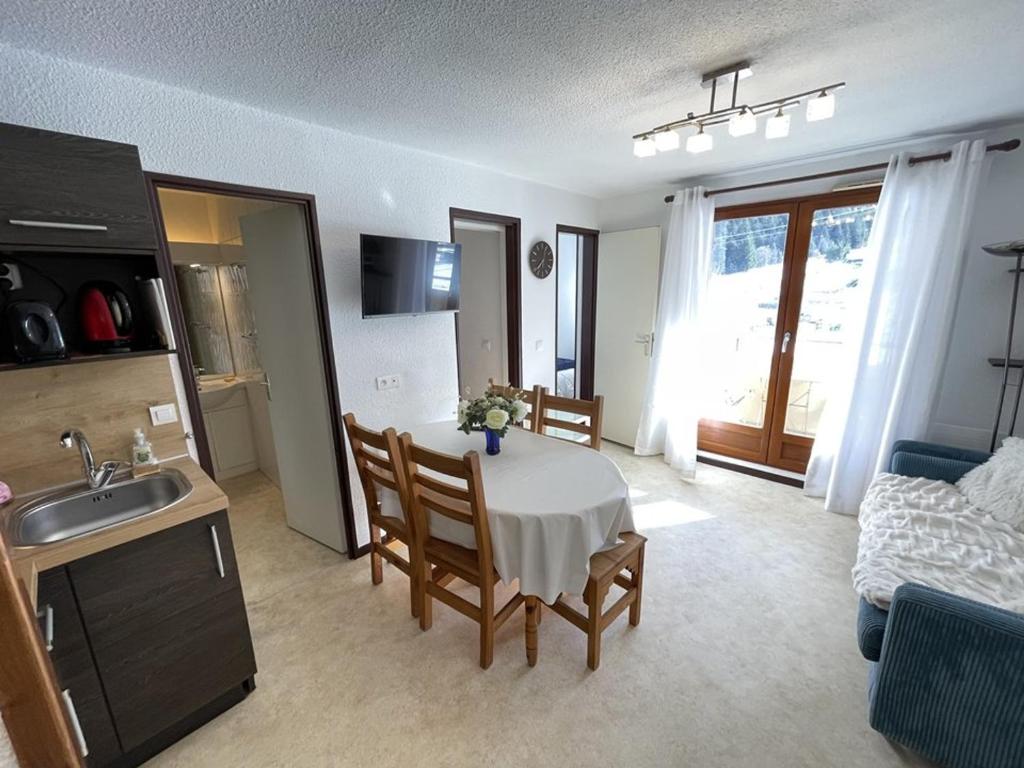 une cuisine et un salon avec une table et des chaises dans l'établissement T2 cabine fonctionnel près des pistes, idéal 4-6 pers - FR-1-787-101, à Laveissière