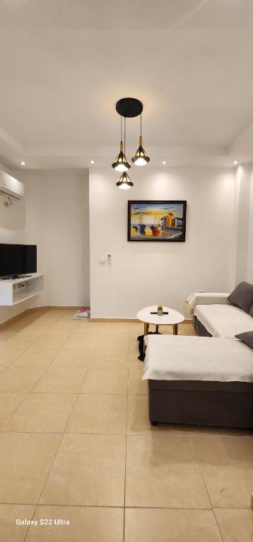 a bedroom with a bed and a couch and a table at Seasons Apartment's Vlora in Vlorë