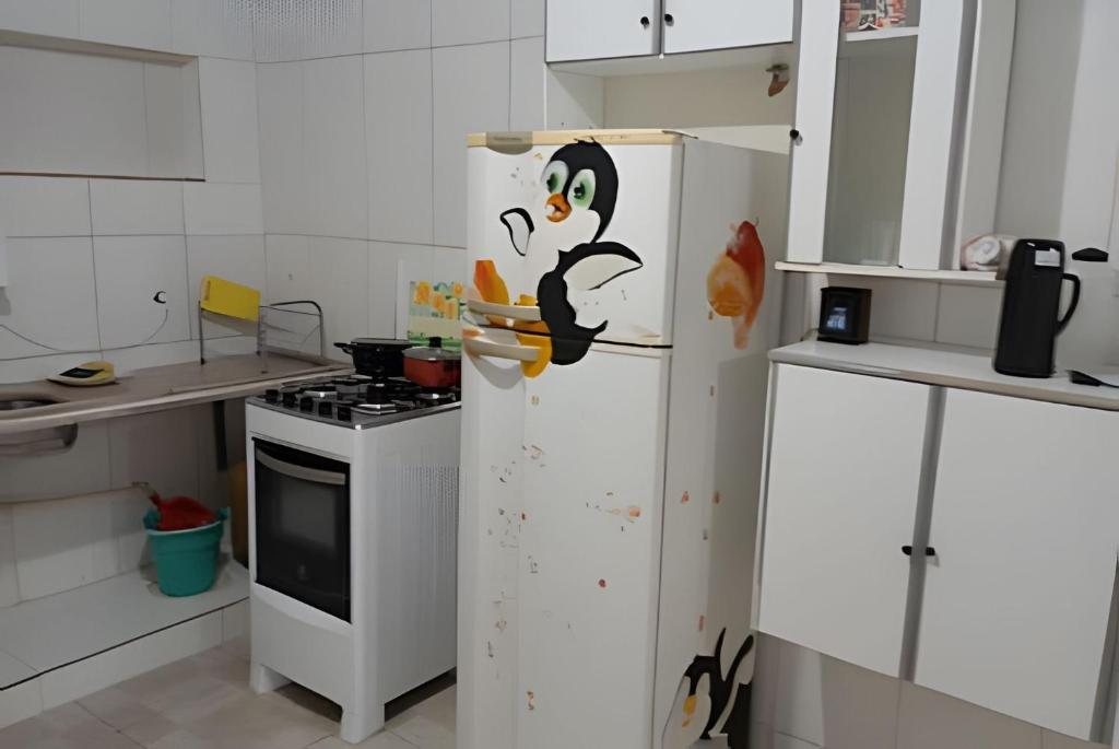 a kitchen with a refrigerator with a penguin on it at kitnet 01 preço popular in Brasília