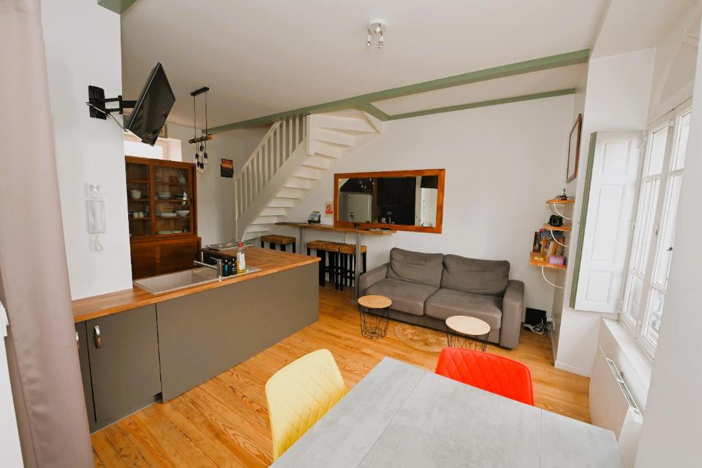 une cuisine et un salon avec un canapé dans l'établissement Les Petits Loups - Accès parc - Stationnement gratuit, à Bagnères-de-Bigorre