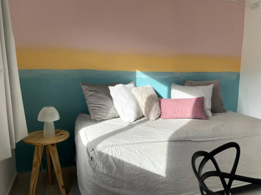a bedroom with a bed with a colorful headboard at EKÜ Chapa Tiny House - Playa Luna Roja 2 in La Estafeta